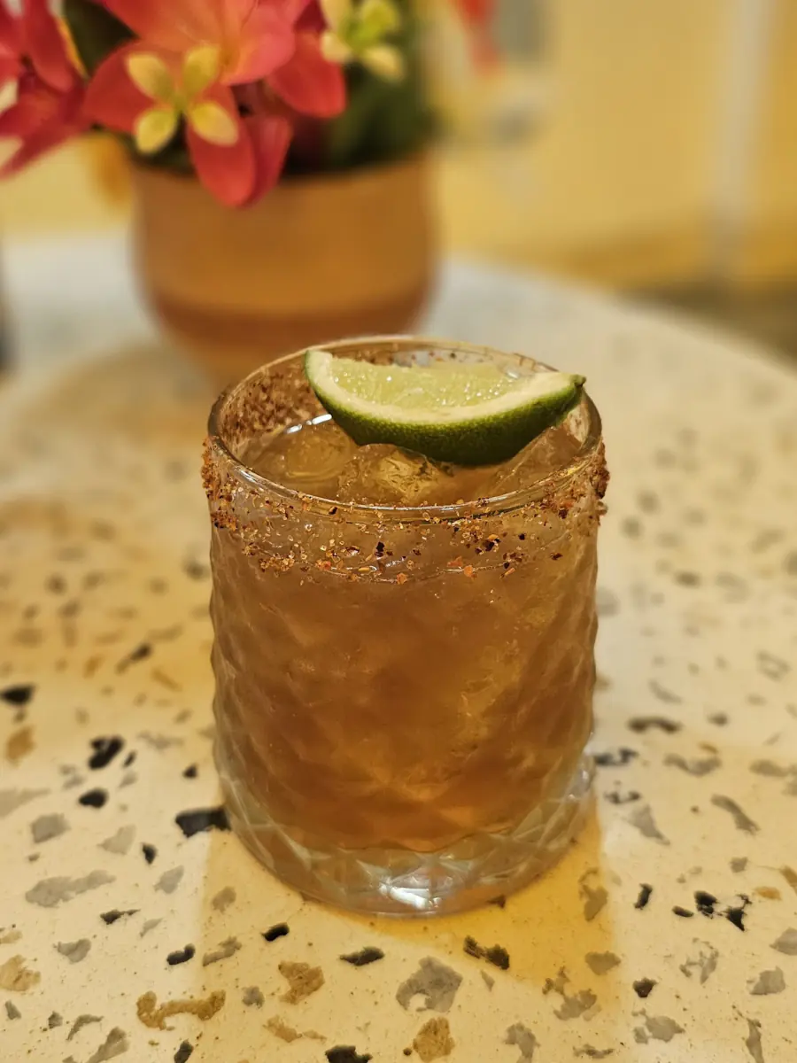 Bebida fría con limón sobre una mesa de terrazo en Mexique
