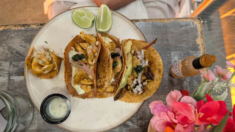 Plato de tacos con limón y salsa en una mesa de Mexique